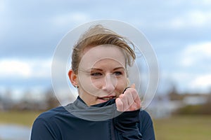 Pretty young woman snuggling into her sports top