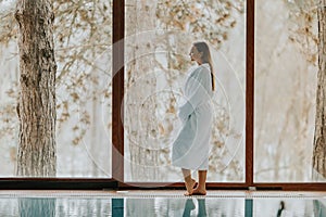 Pretty young woman standing by swimming pool