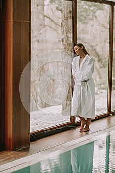 Pretty young woman standing by swimming pool