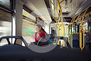 Pretty, young woman on a streetcar/ autobus, during her commute