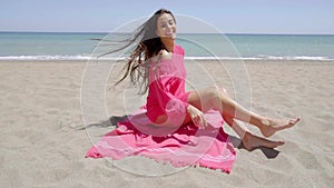 Pretty young woman sunbathing in a pink tunic