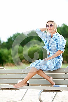 Pretty young woman sunglasses sitting on bench