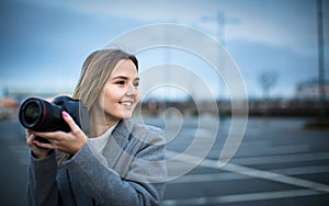 Pretty, young woman taking photos with her  camera