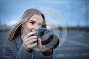 Pretty, young woman taking photos with her  camera