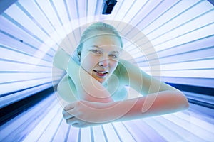 Pretty, young woman tanning her skin