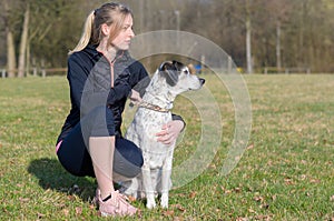 Pretty young woman teaching her dog commands