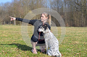 Pretty young woman teaching her dog commands