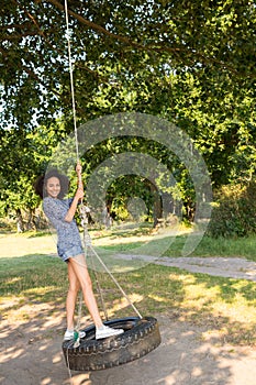 Pretty young woman in tire swing