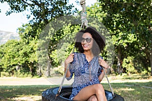 Pretty young woman in tire swing