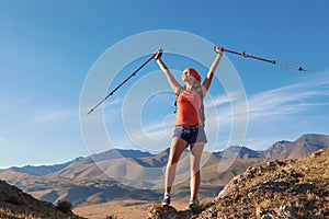 Pretty young woman tourist standing on top of mountain