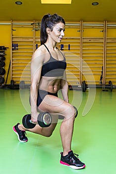 Pretty young woman training with dumbbels