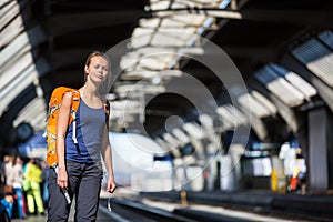 Pretty, young woman in a trainstation, waiting for her train