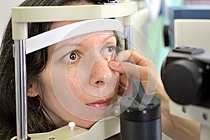 Pretty young woman undergone an ocular fundus inspection with ophthalmologist optometrist optician photo