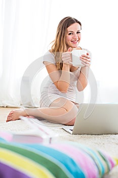 Pretty, young woman using a laptop computer at home