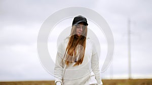 A pretty young woman walking on an autumn field. Going towards the camera