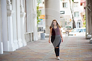 Pretty young woman walking on the city street. Casual fashion, plus size model. xxl women on nature.