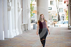 Pretty young woman walking on the city street. Casual fashion, plus size model. xxl women on nature.