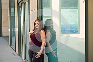 Pretty young woman walking on the city street. Casual fashion, plus size model. xxl women on nature