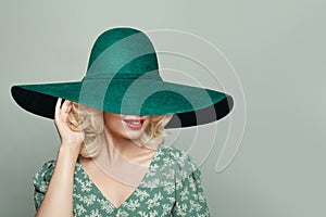 Pretty young woman wearing dress and green tourquoise wide broad brim hat photo