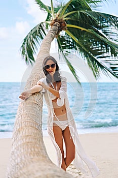 Pretty young woman in white bikini enjoy her tropical beach vacation