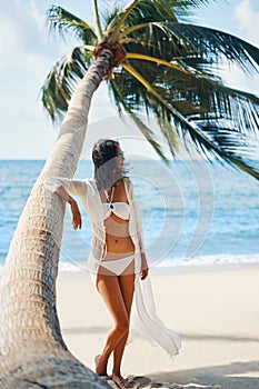 Pretty young woman in white bikini enjoy her tropical beach vacation