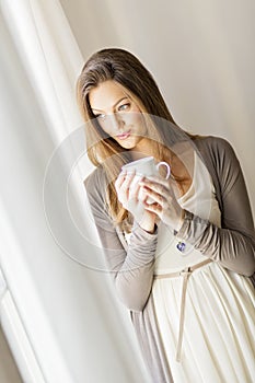 Pretty young woman by the window