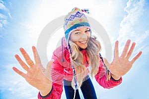 Pretty young woman in winter day dressed in woolen hat showing o