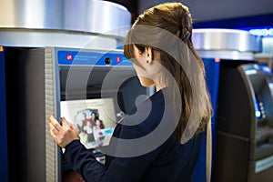 Pretty, young woman withdrawing money from her credit card photo
