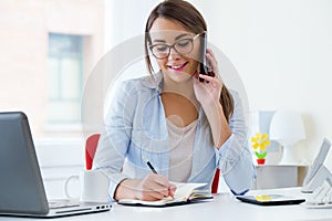 Pretty young woman working in her office.