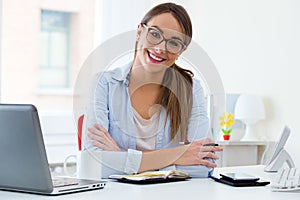 Pretty young woman working in her office.