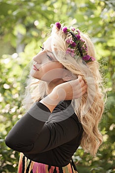 Pretty young woman with wreath of flowers in hair portrait outdo
