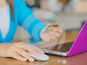 Pretty Young womans hands holding a credit card and using tablet, smartphone and laptop computer