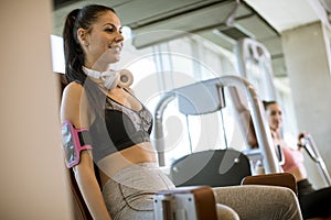 Young woman having a training at abductor machine in the gym
