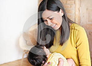 Pretty young woman holding a newborn baby in her arms. Happy family concept