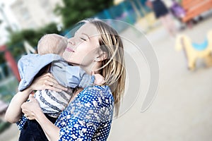 Prettyl happy mather with baby boy Embracing him emotionally on a liking