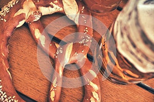 Pretzel Brezeln with Sea Salt and Glass of Beer on Rustic Wooden Table