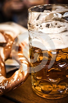 Pretzel Brezeln with Sea Salt and Glass of Beer on Rustic Wooden Table