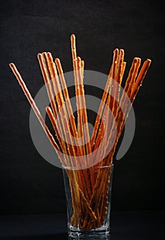 Pretzel sticks in small glass photo