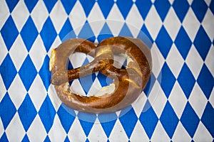 Pretzel on white / blue background. Rhombuses, Bavarian colors