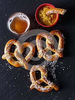 Pretzels and mustard on slate table