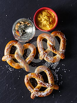 Pretzels and mustard on slate table photo