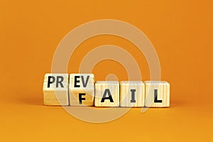 Prevail or fail symbol. Concept words Prevail or Fail on wooden cubes. Beautiful orange table orange background. Business prevail