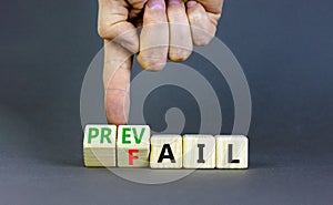 Prevail or fail symbol. Concept words Prevail or Fail on wooden cubes. Businessman hand. Beautiful grey table grey background.