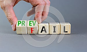 Prevail or fail symbol. Concept words Prevail or Fail on wooden cubes. Businessman hand. Beautiful grey table grey background.