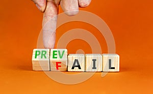 Prevail or fail symbol. Concept words Prevail or Fail on wooden cubes. Businessman hand. Beautiful orange table orange background