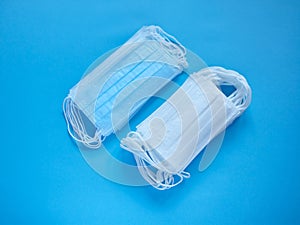 Prevent coronavirus. Medical protective masks isolated on blue background. Disposable surgical face mask cover mouth and nose.