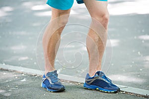 Prevent varicose concept. Legs of male athlete runner jogging park sidewalk. Training cardio in proper sport shoes