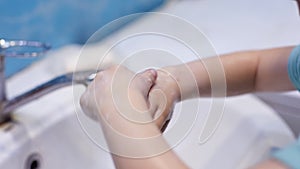 Preventing the covid-19 coronavirus pandemic, a little girl washes her hands with soap and a sanitizer