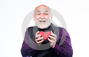 Preventing heart attack. Senior bald head bearded man holding red toy heart in hands. Mature man with valentines heart