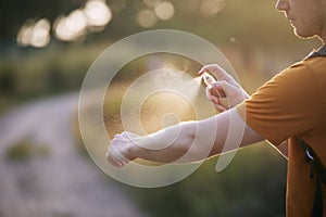Man applying insect repellent on his hand photo